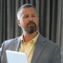 Brent Skinner, Executive Community Leader for Future of Payroll at HR.com seen posing for a photo in a yellow color shirt and grey color suit